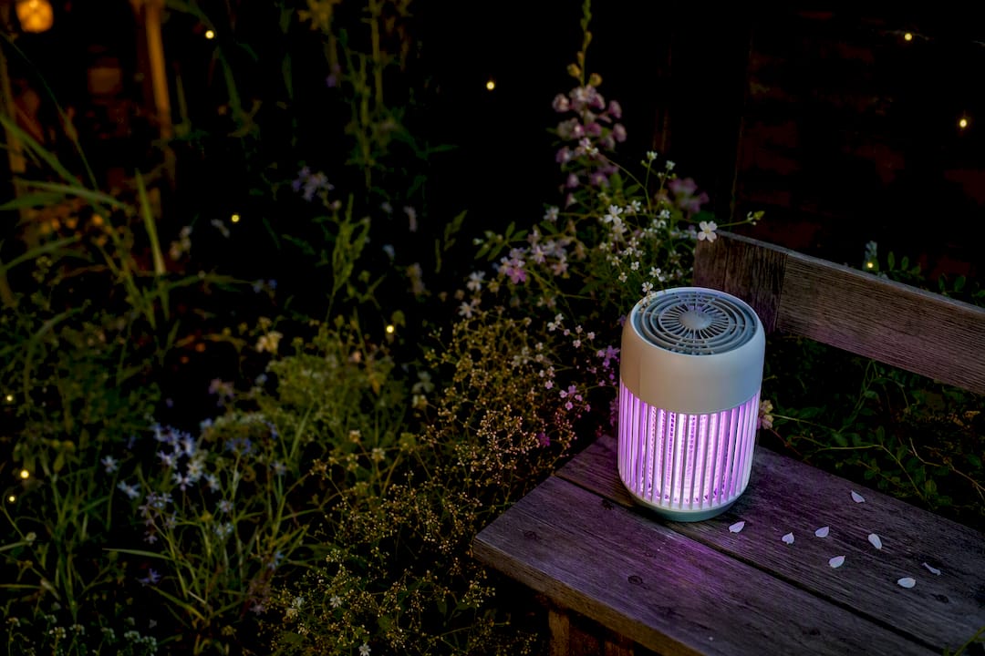 Mosquito zapper glowing on patio table at dusk