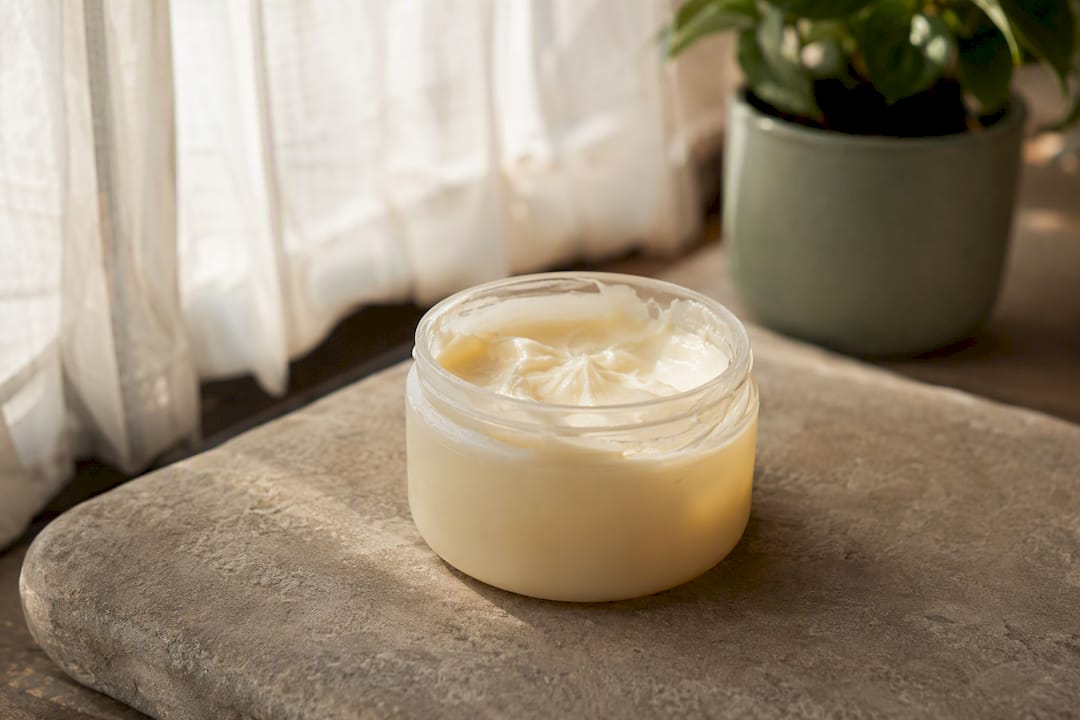 Partially melted body butter jar on wooden surface