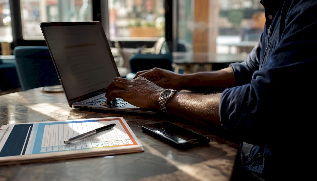 Hands typing on laptop with driver checklist