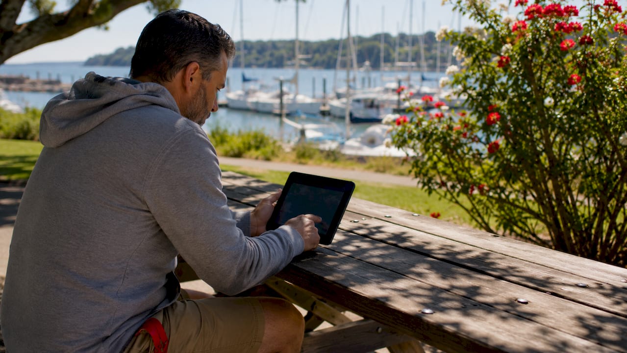 Man verifying boating course on phone at marina