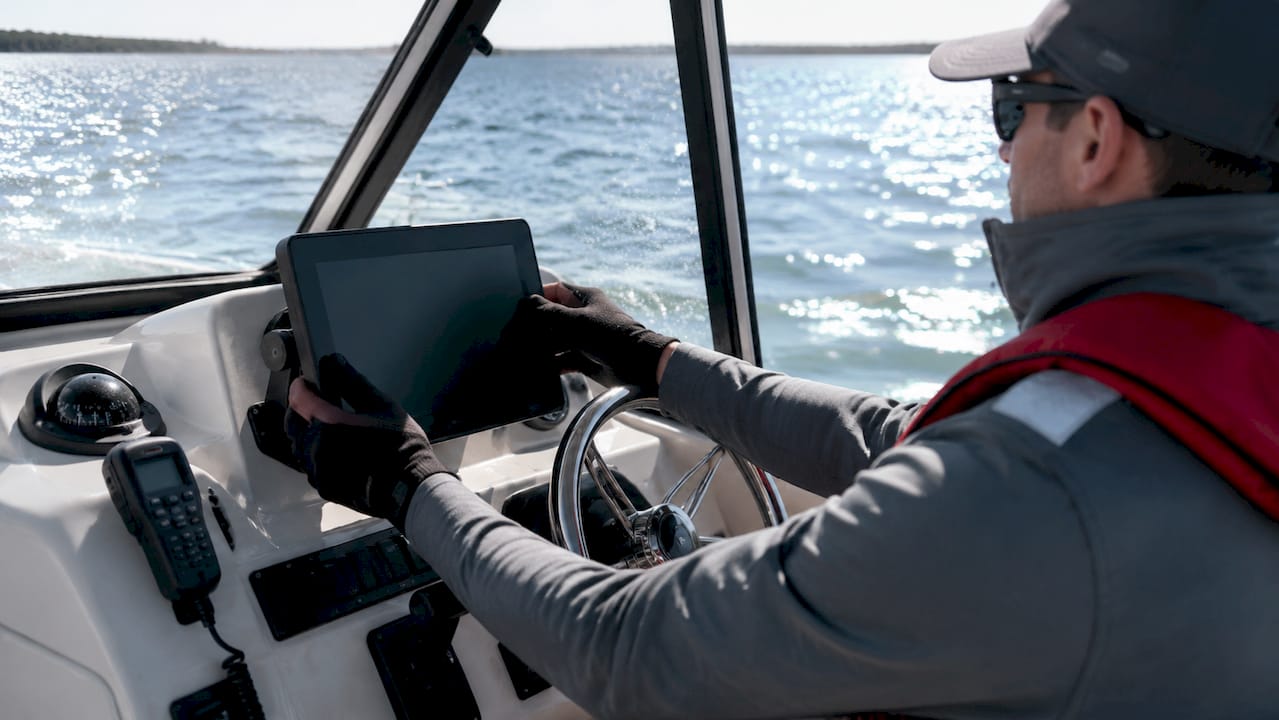 Hands operating GPS chartplotter and marine instruments