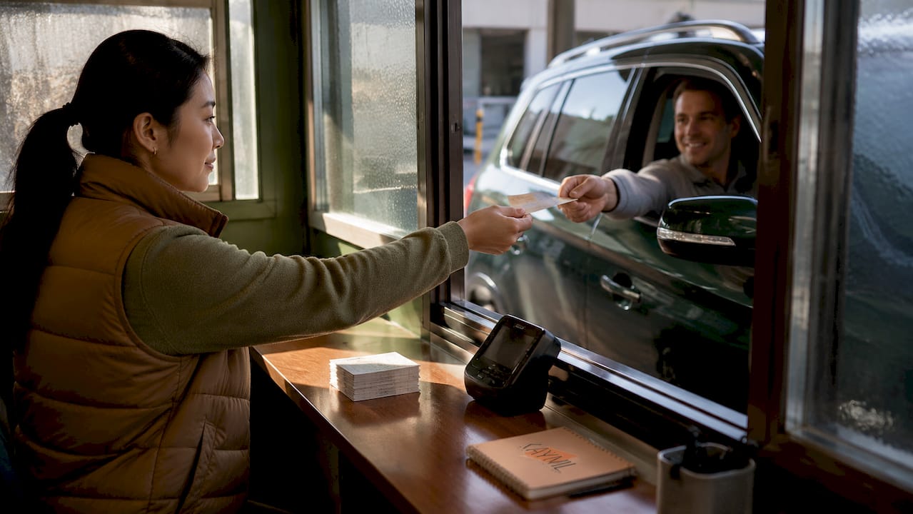 Parking attendant giving transient ticket to driver