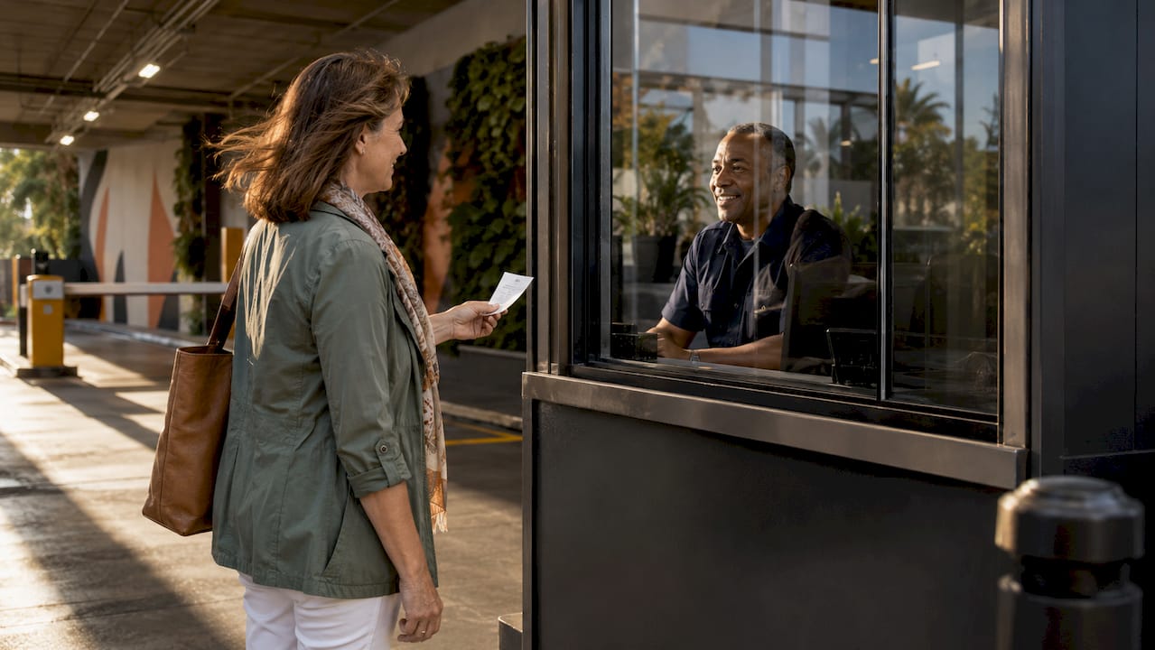 Woman showing parking ticket at garage entrance