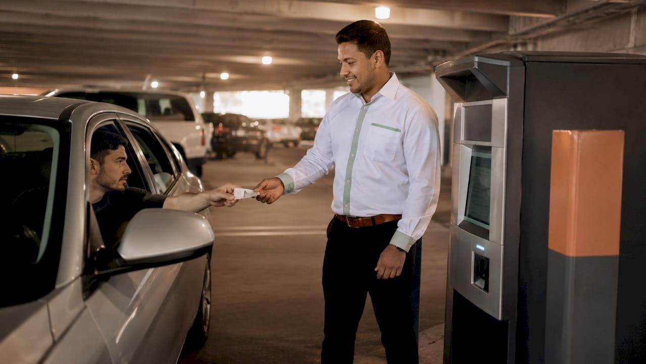 Hands inserting parking ticket into pay station
