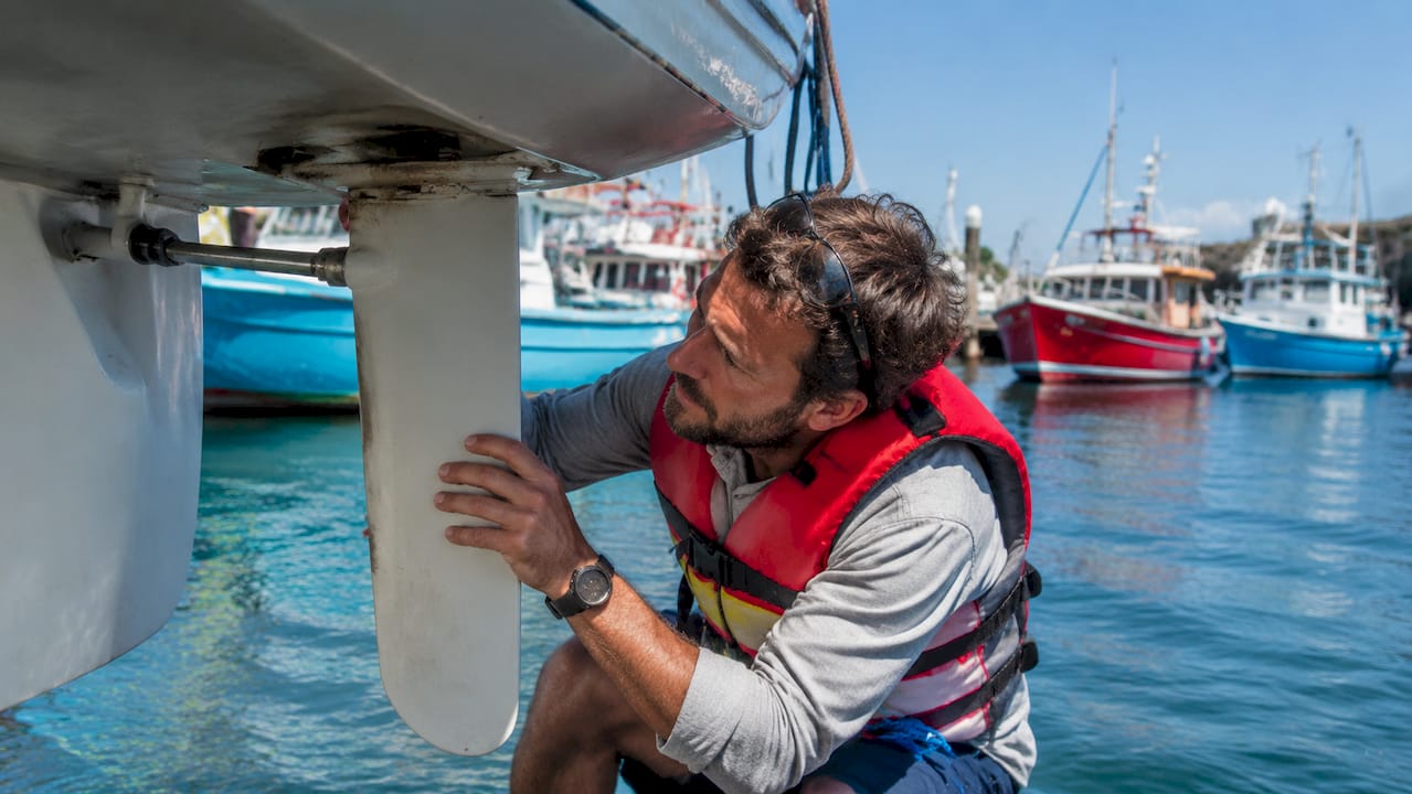 Person inspecting boat hull and beam close-up