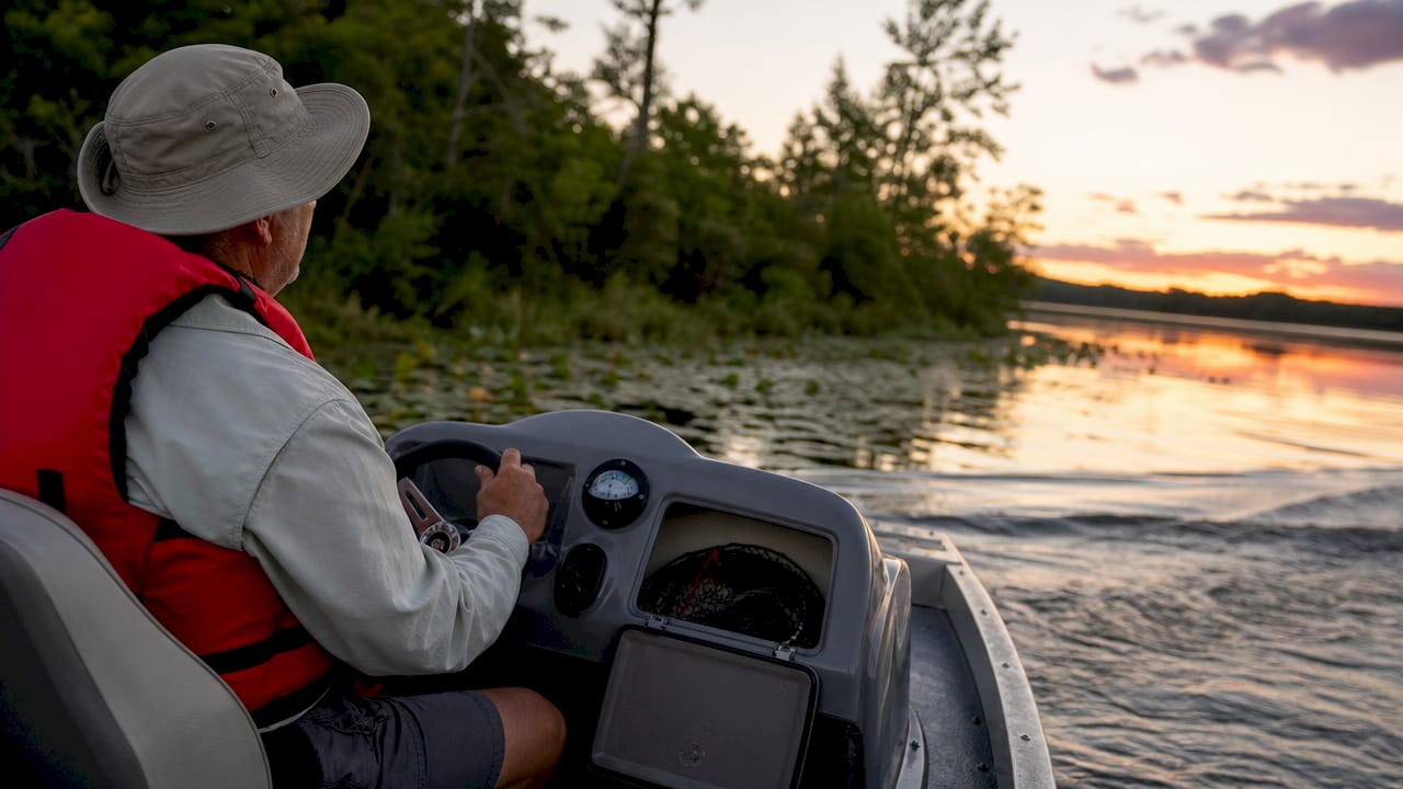 Boater steering boat gently near shoreline to prevent damage