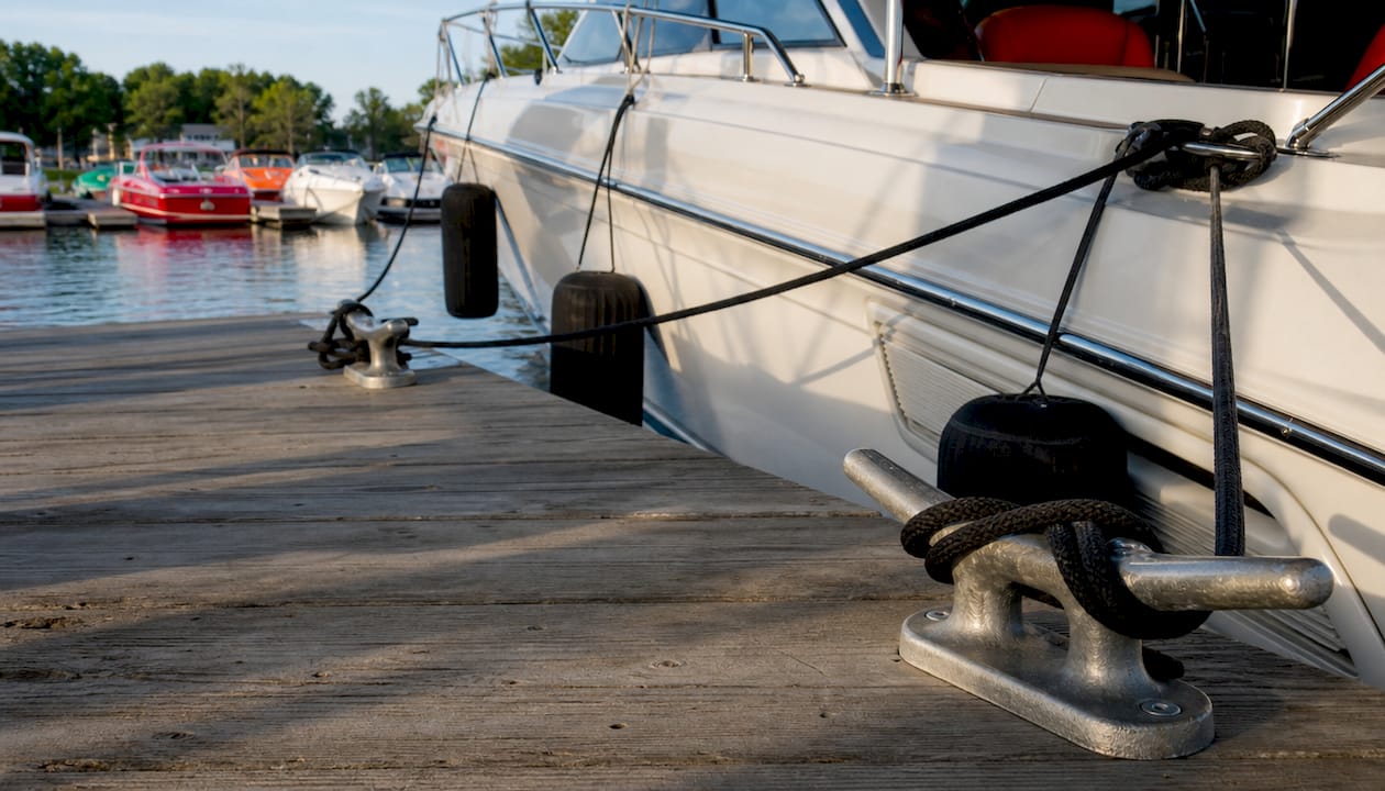 Close-up of mooring lines secured on cleats with fenders