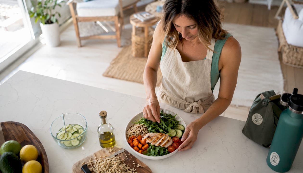 Woman preparing nutritious whole food meal in kitchen