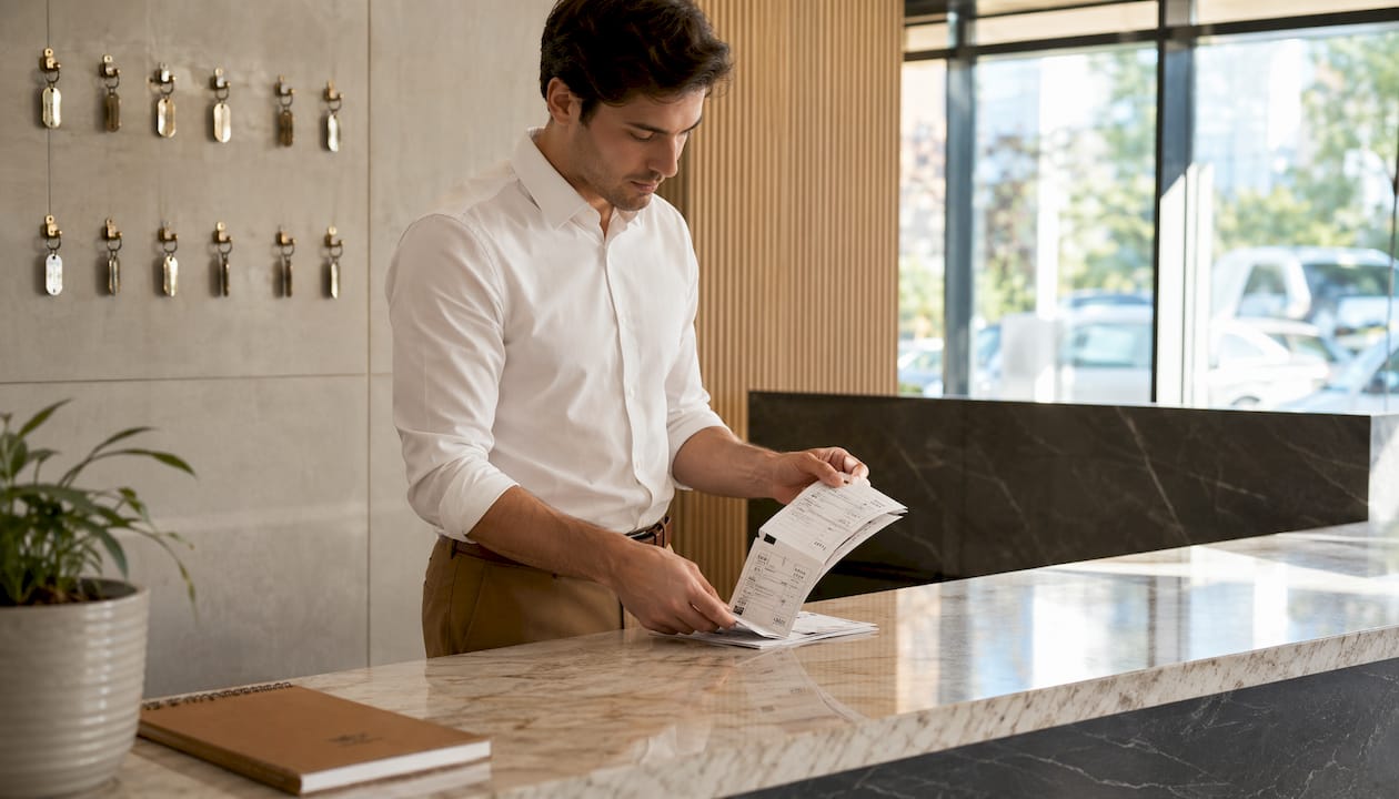 Clerk handling sequential valet parking stubs and key hooks