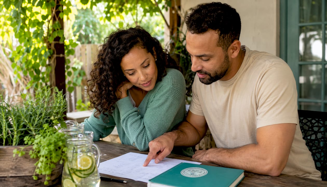 Couple collaborating on diet plan at kitchen table