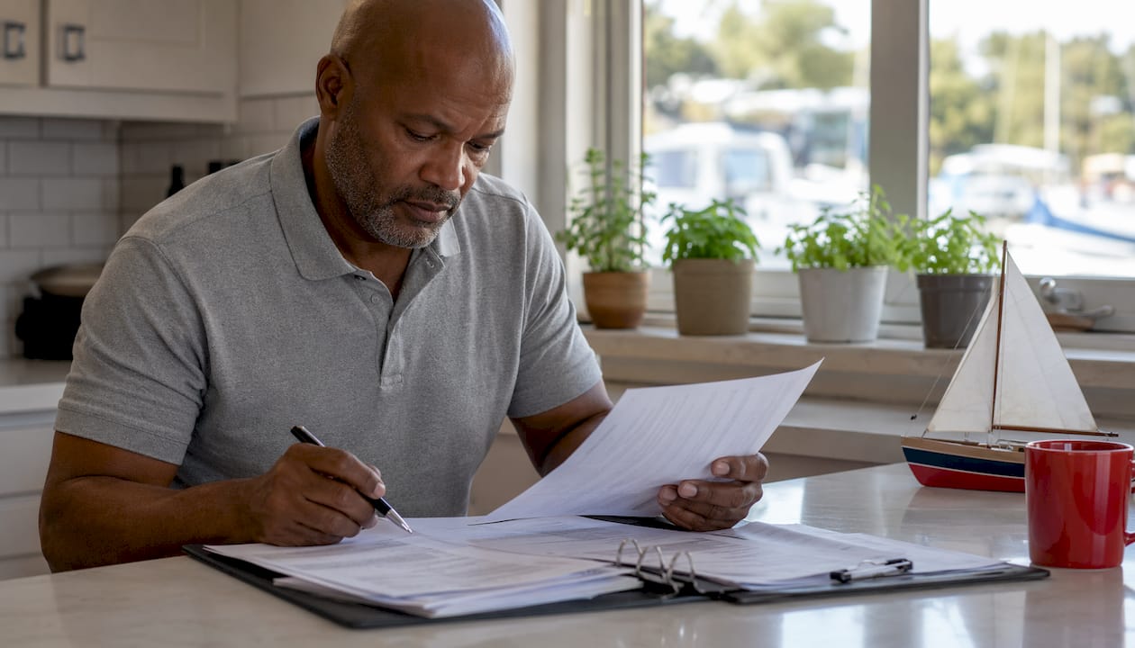 Man reviewing boat insurance papers indoors