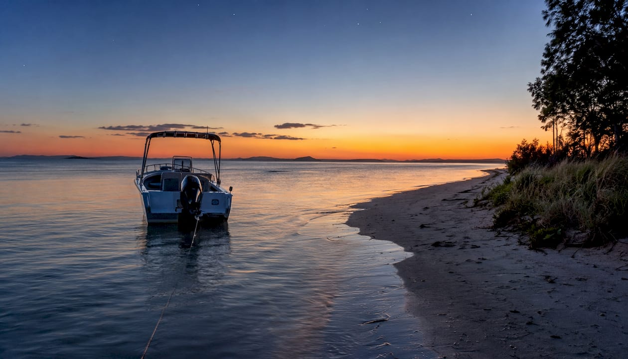 Small boat anchored bow to waves in calm water