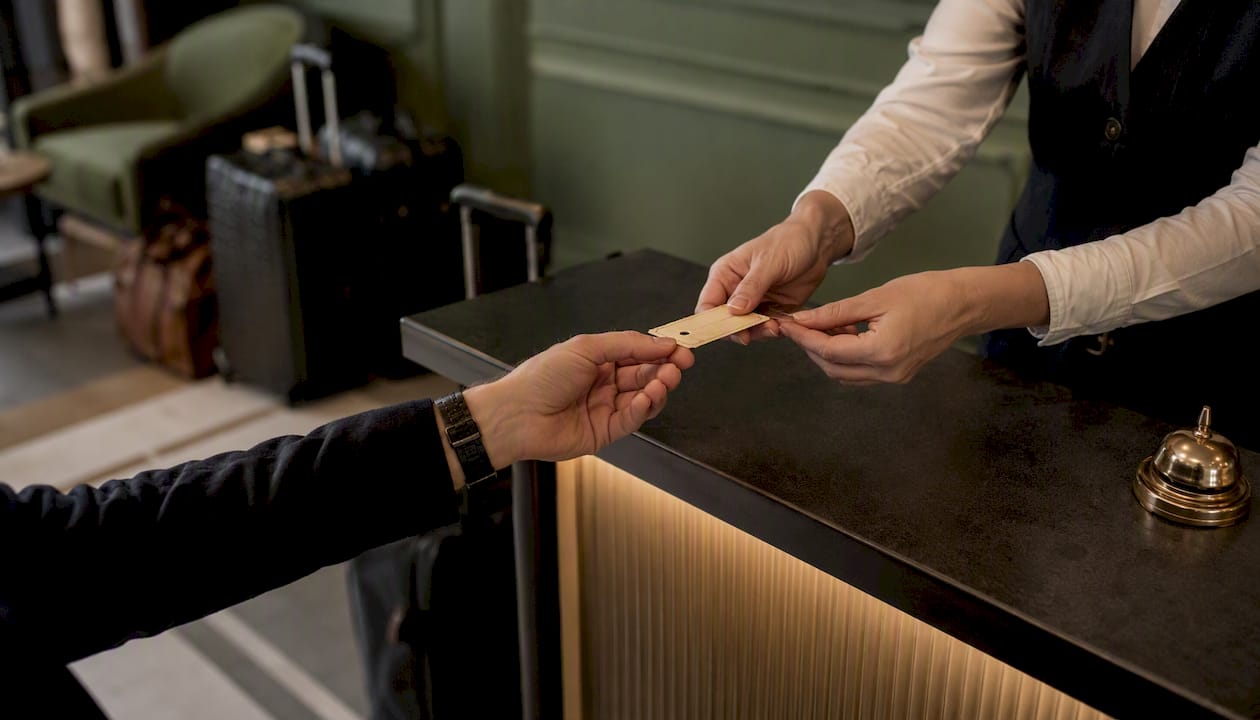 Bell desk attendant handing luggage ticket