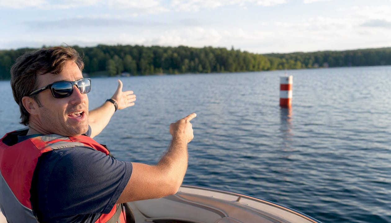 Boater pointing at safe water marker buoy