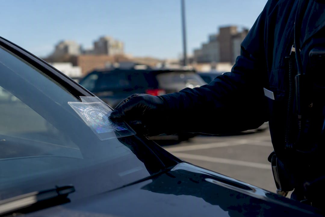 Officer inspecting parking permit inside vehicle