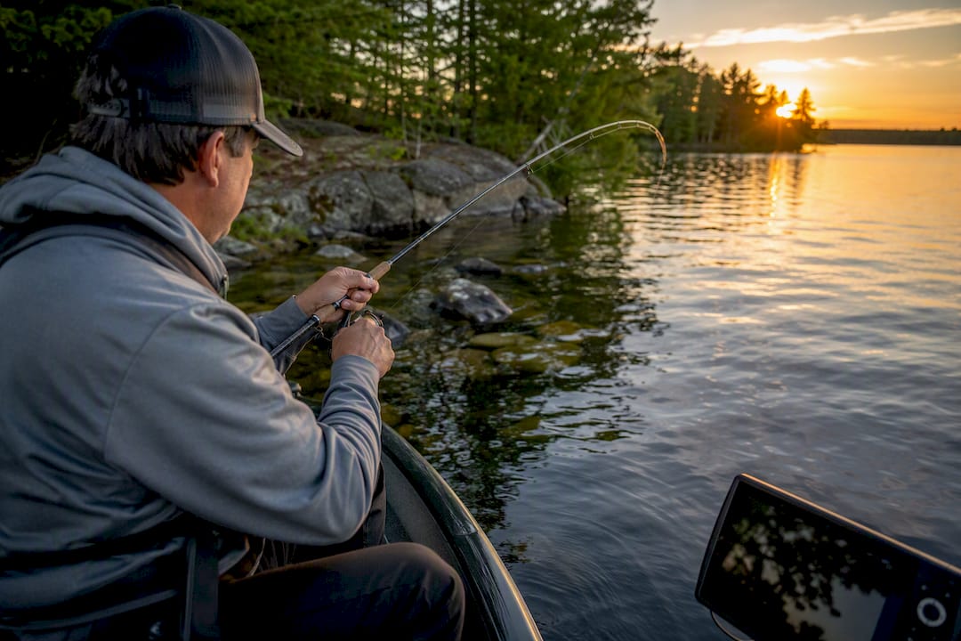 Fisherman preparing rod on lake near underwater structures