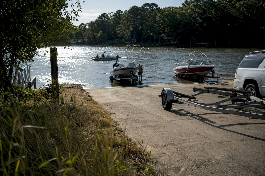 Public boat ramp with parked trailers at a lake