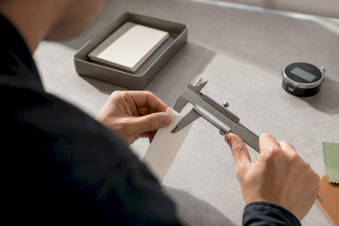 Technician checking ticket sample thickness