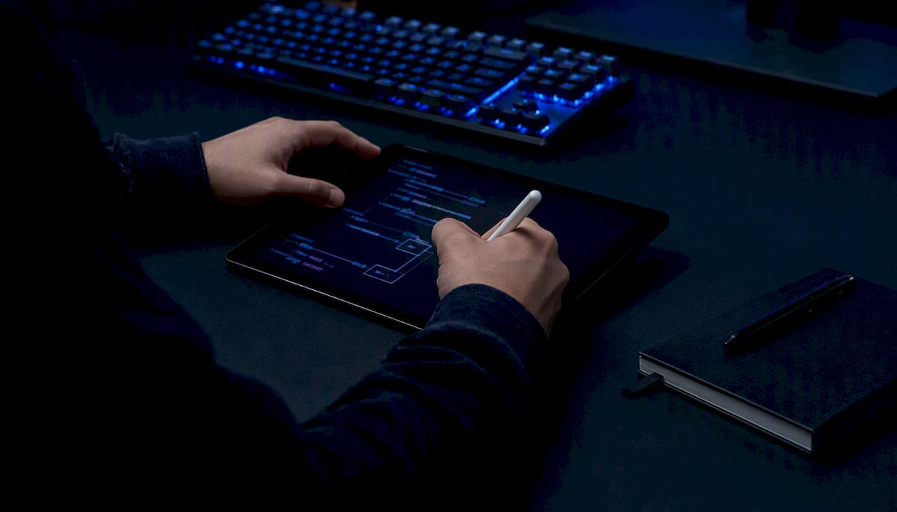 Hands reviewing validation code on paper at blue-lit desk