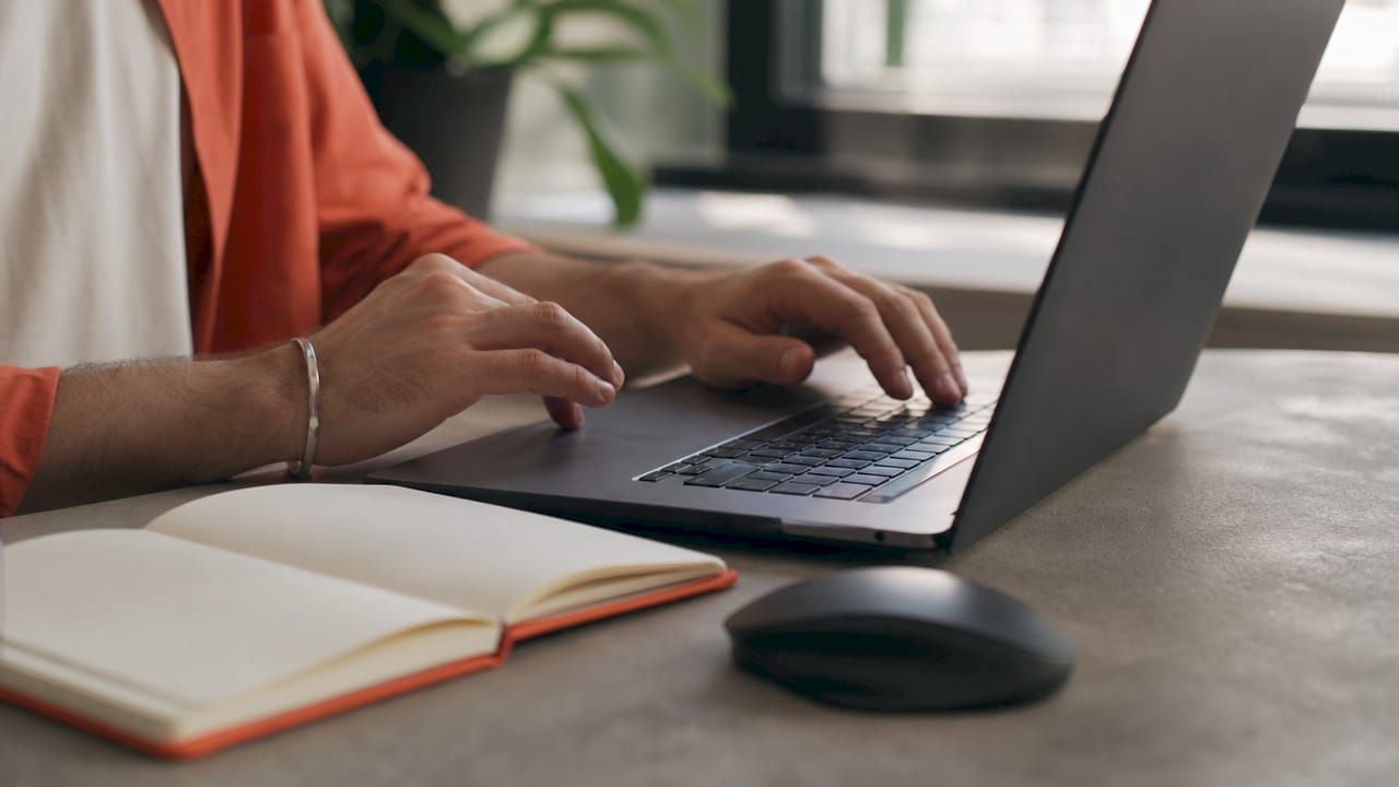 Hands adjusting Google Ads campaign schedule on laptop