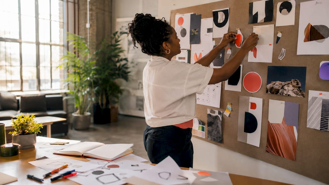 Hands placing brand stickers on inspiration board