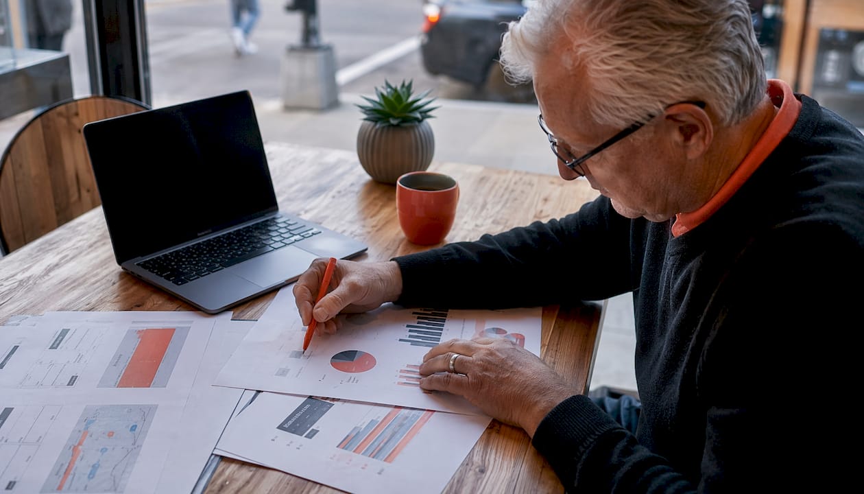 Hands typing with ad metrics and notes nearby