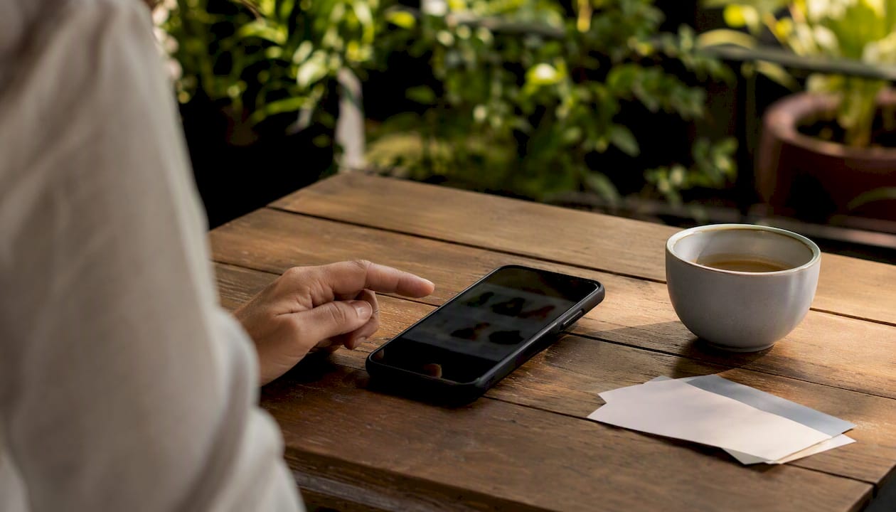 Hand holding smartphone with blurred product page