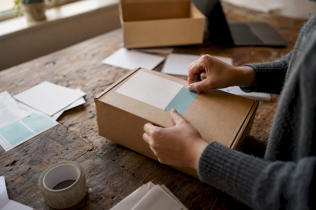Hands applying shipping stickers to parcel