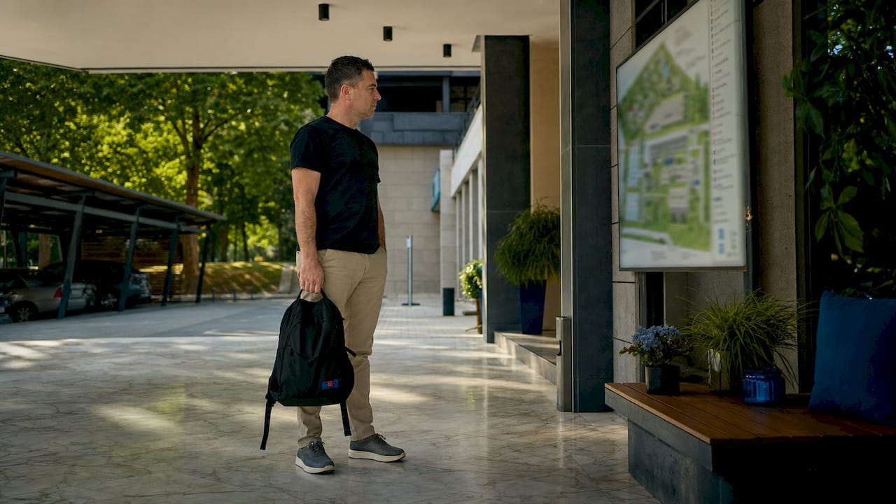 Gost stoji kod ulaza u hotel i proučava mapu parkinga, pokušavajući da se snađe gde može da ostavi svoj automobil.