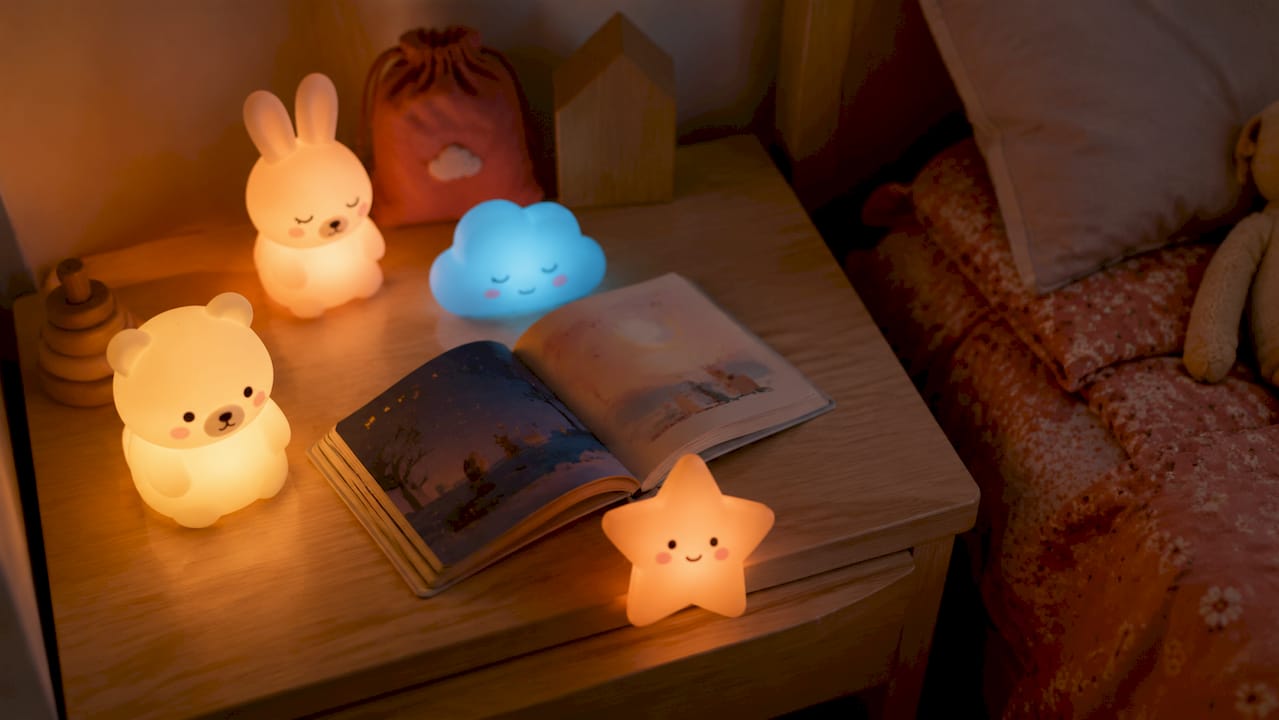 Une sélection de veilleuses multicolores posées sur une table de chevet