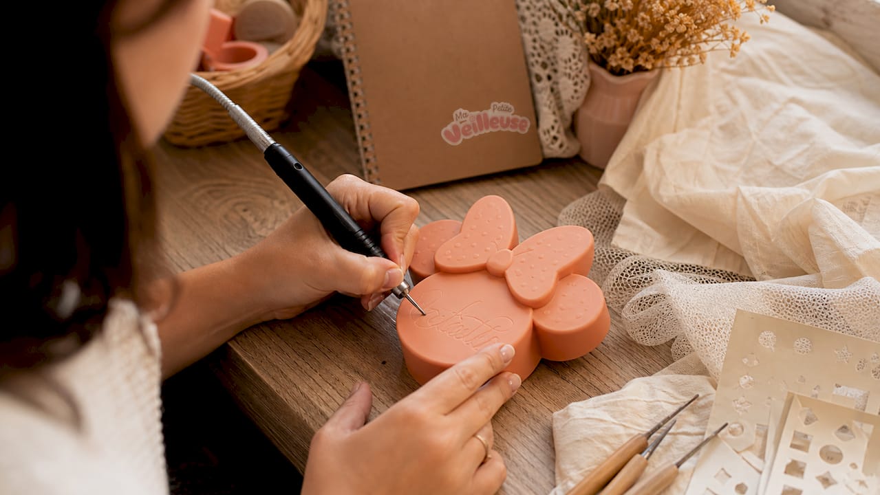 Un artisan en train de personnaliser une veilleuse Minnie
