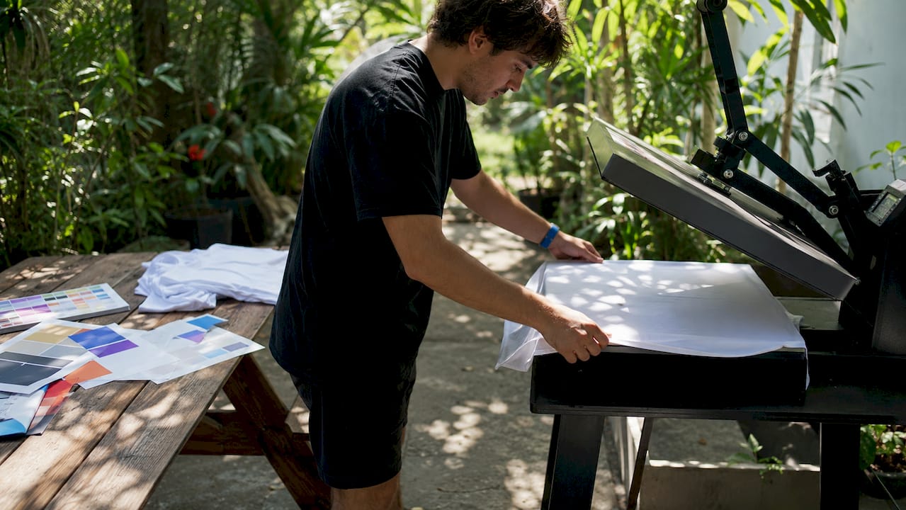 Hands positioning t-shirt on heat press