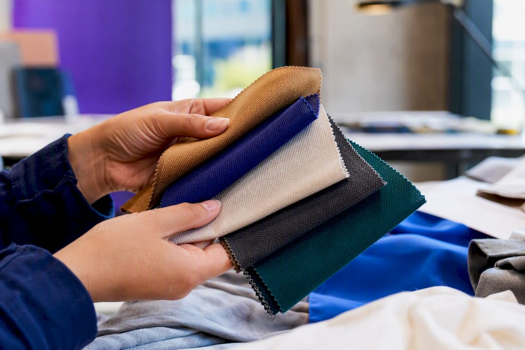 Hands holding sustainable fabric swatches