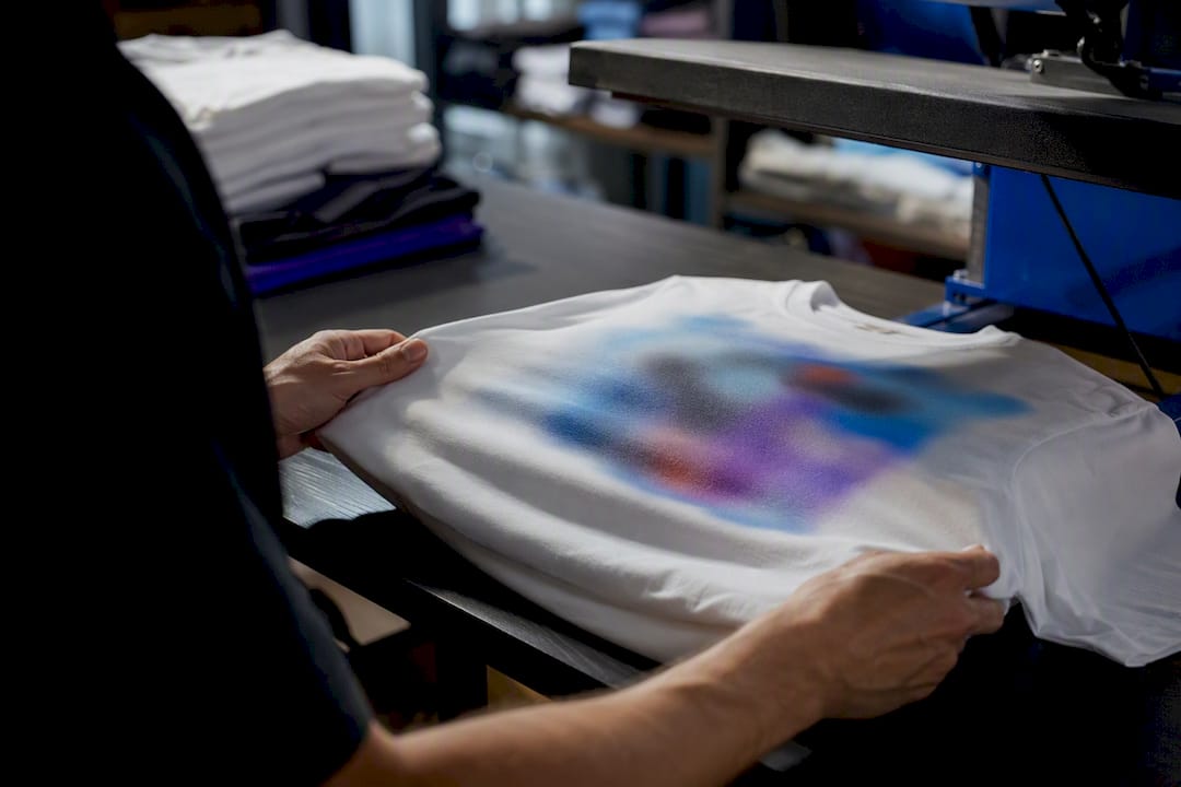 Hands inspecting t-shirt print sample