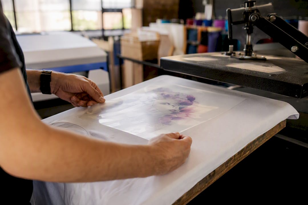 Hands positioning PET film for DTF heat transfer