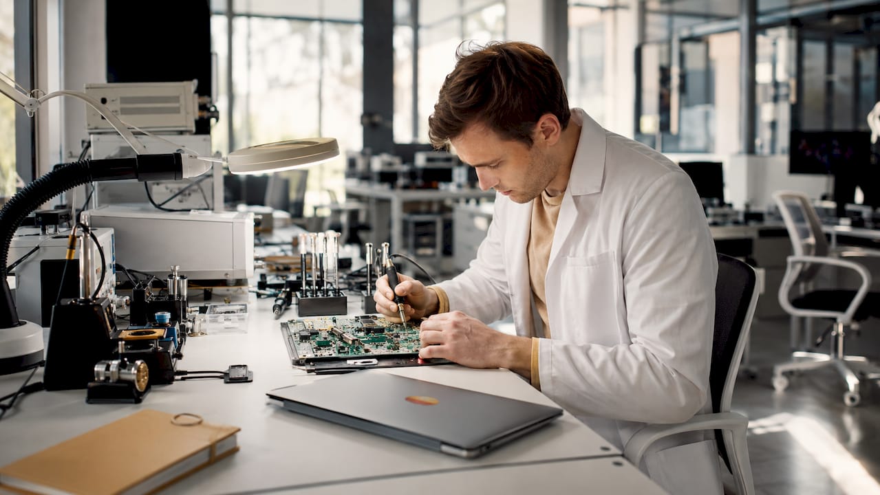 Technician soldering microprocessor on beauty device circuit board