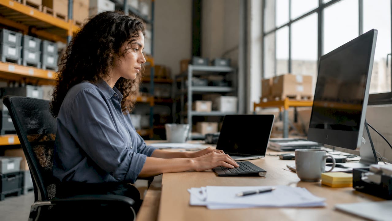 Una donna al lavoro, impegnata a gestire l’inventario tramite un software di intelligenza artificiale nel suo ufficio.