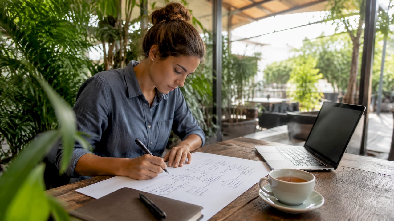 Mani che disegnano i flussi dei processi aziendali su un foglio