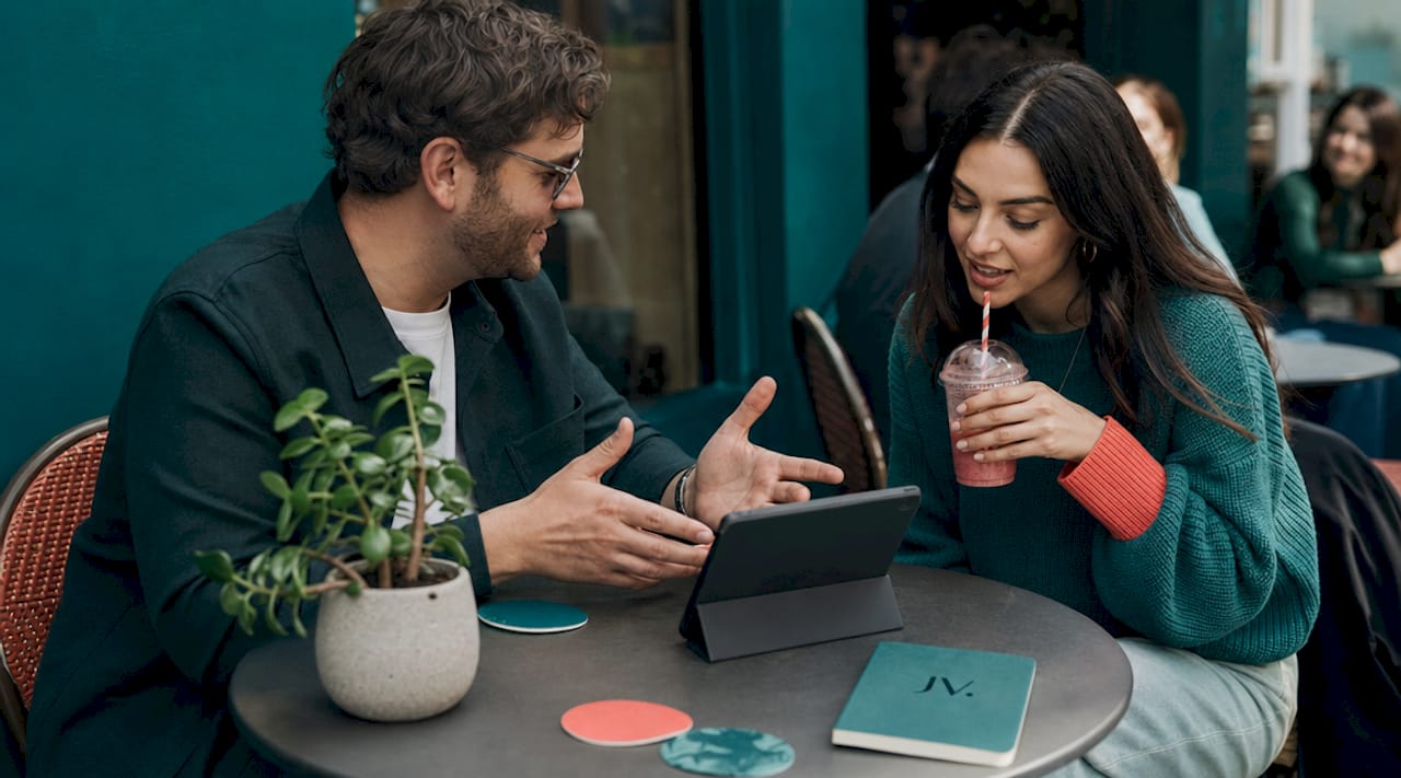 Two friends discussing fashion deals over coffee