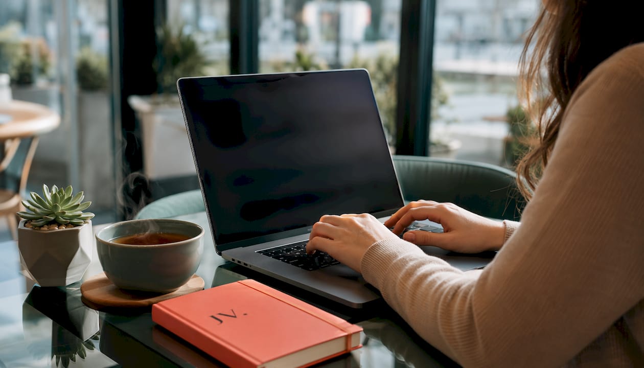 Hands entering discount code on laptop keyboard