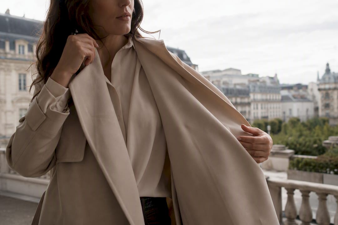 Woman layering neutral blazer over vest
