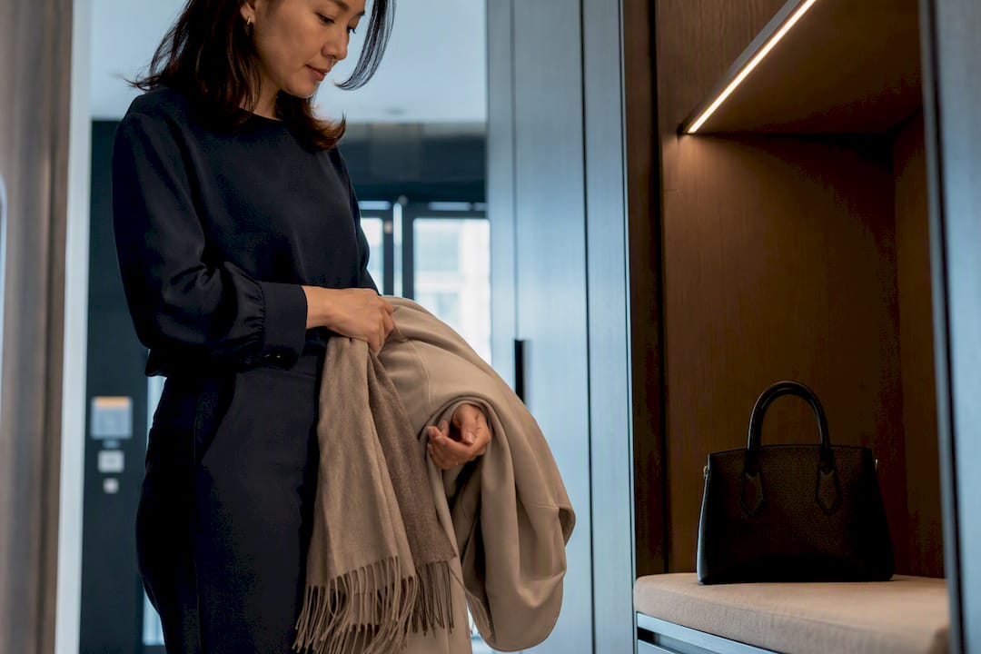 Woman removing coat and folding interview scarf