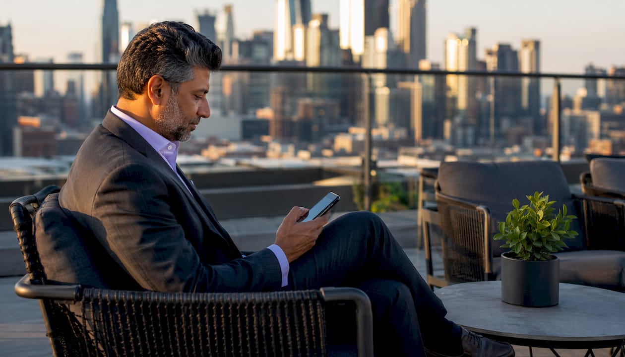 Executive reviewing LinkedIn content on phone in office