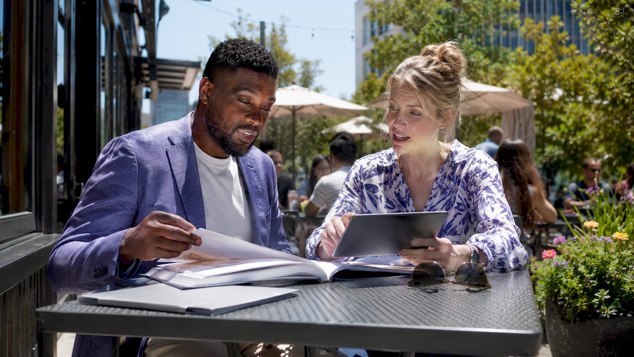 Two professionals discussing portfolio plans in café