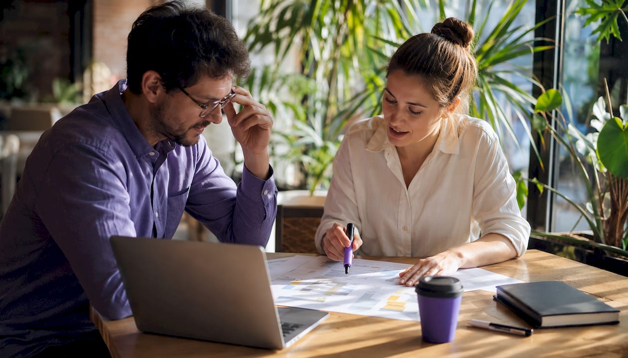 Professionals reviewing business data flow charts
