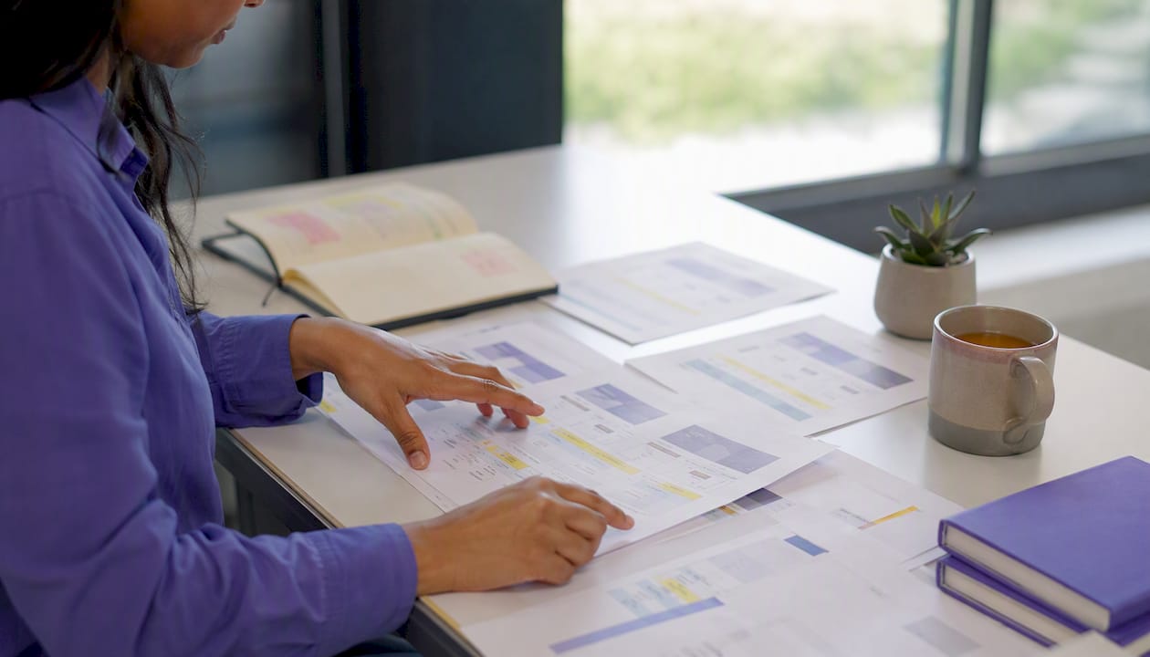 Hands arranging consulting subscription offer sheets on desk