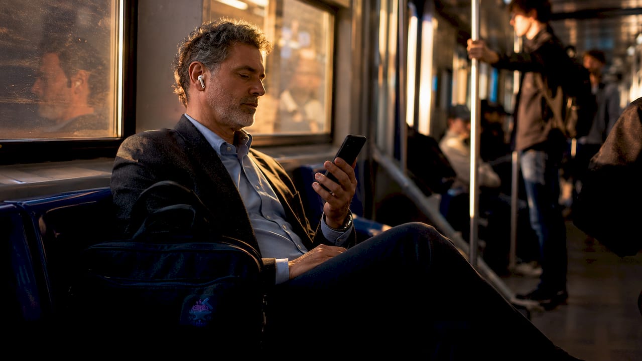 Man listening to audiobook on subway commute