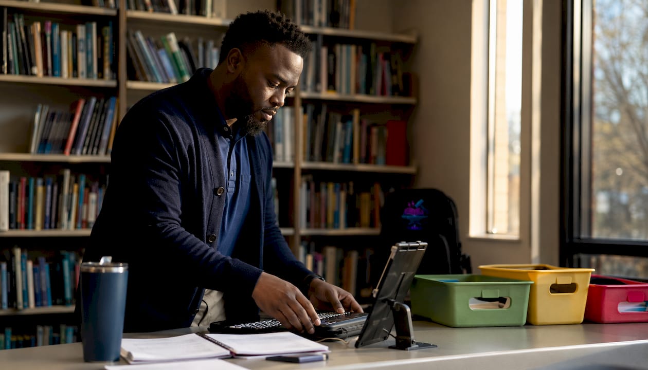 Teacher preparing assistive tech in accessible classroom