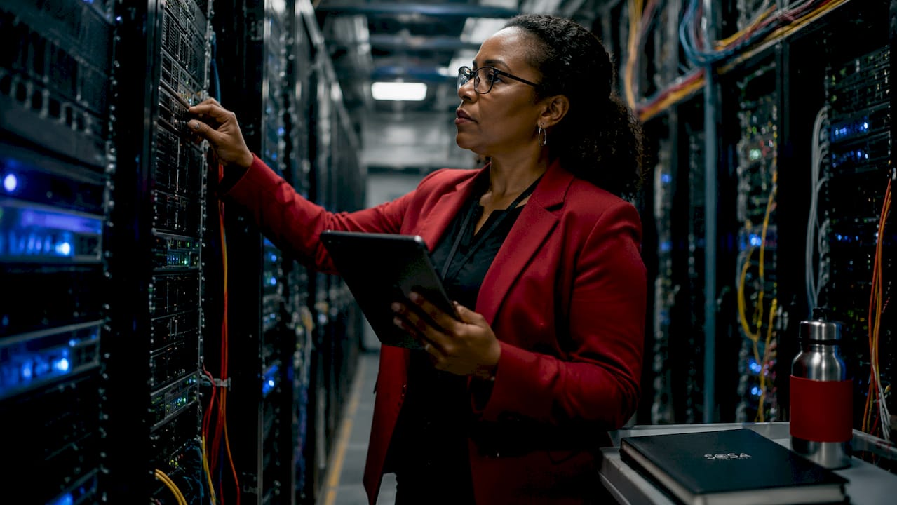 Systems engineer inspecting servers in data center