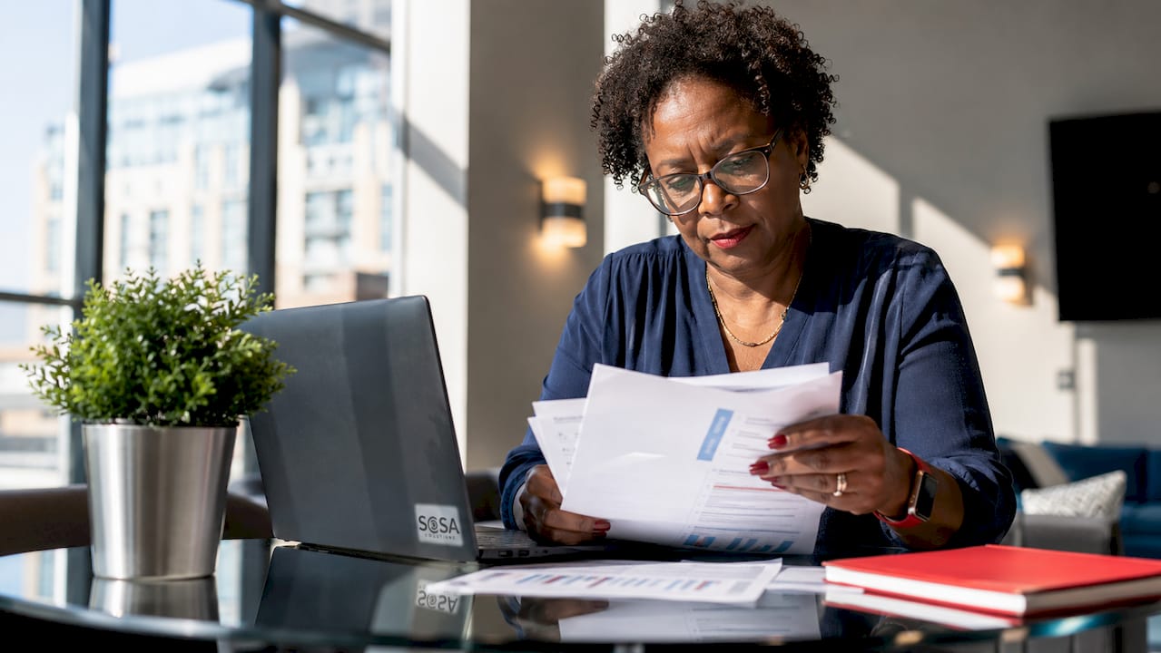 Woman reviewing IT vendor proposals at desk